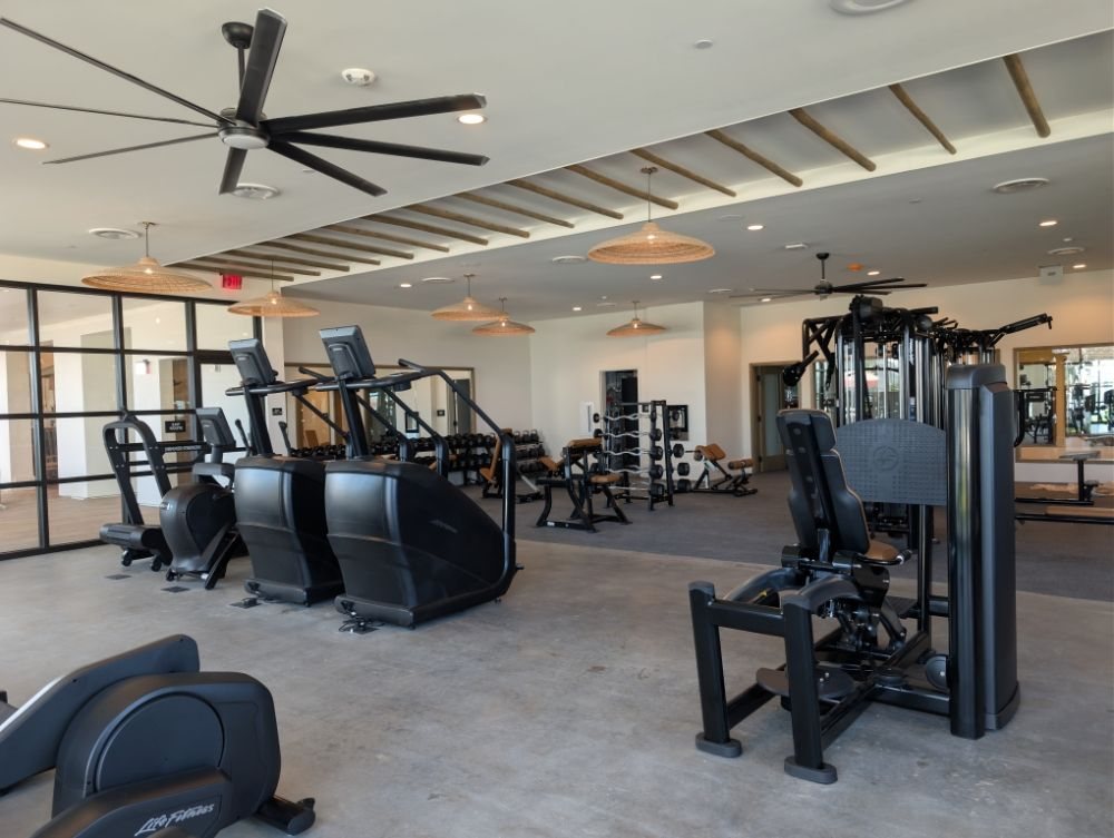 A commercial fitness room with new lighting and ceiling fans
