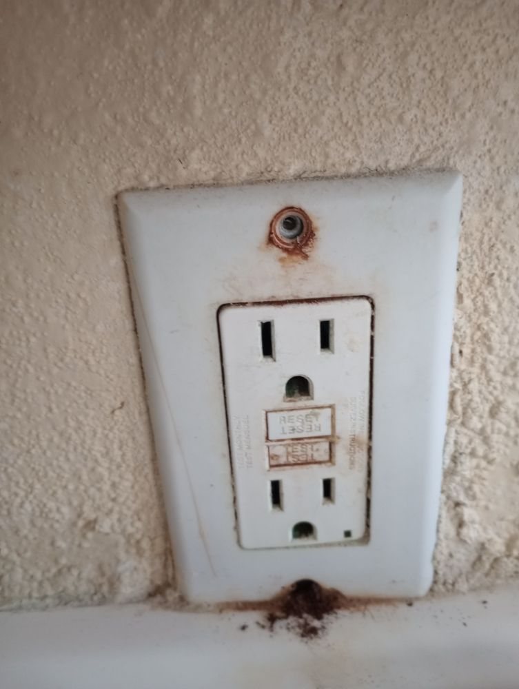 A worn, rusted outlet before replacement